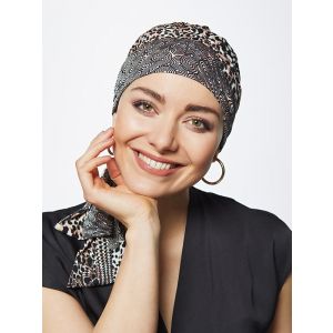 Vrouw draagt een chemo hoofddoekje in een mooie print