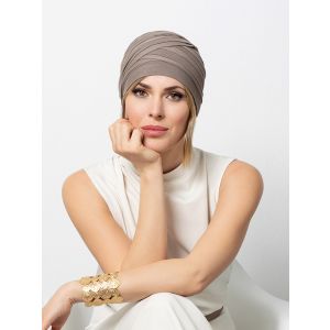 Vrouw draagt een grijze turban van Gisela Mayer
