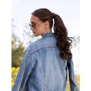 Vrouw draagt een wavy haarstuk voor een vollere paardenstaart