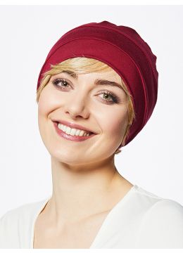 Vrouw draagt een rood mutsje van Gisela Mayer